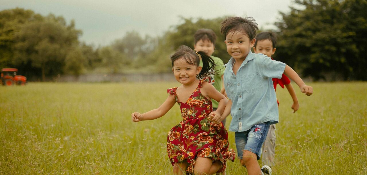 Happy children running in field cropped and flipped